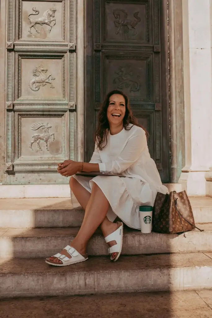 Nicole in white dress sitting on steps